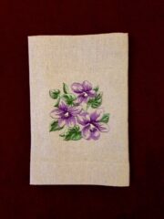 Purple flowers embroidered on a linen towel.