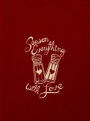 A red tee shirt with the words "Season Everything With Love" embroidered on it.
