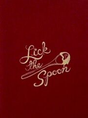 A red napkin with the "Lick The Spoon" Embroidered Flour Sack Towel on it.