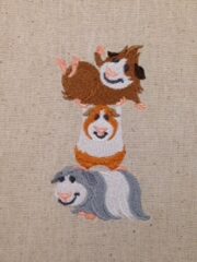 Three Guinea Pig Stack Embroidered Osnaburg Towels sitting on top of each other.