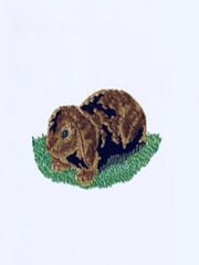 A black and brown Lop-eared Rabbit embroidered on a white shirt.