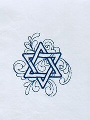 A white napkin with a Star of David Embroidered Deluxe Flour Sack Towel (blue) on it.