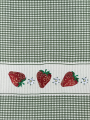 A green and white gingham towel with strawberries on it.